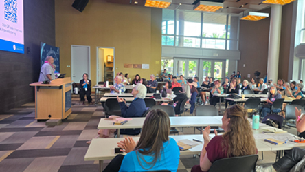 event attendees listening and applauding speaker